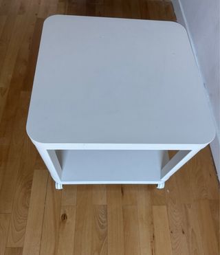 Mesa auxiliar blanca con ruedas y planta