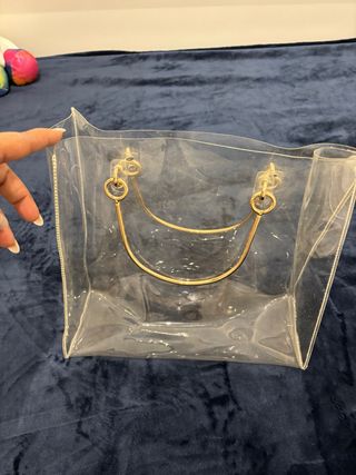 Bolso transparente con asas doradas