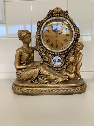 Reloj de sobremesa dorado con figuras