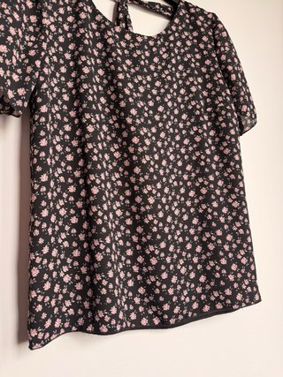 Blusa nera con fiori rosa e fiocco