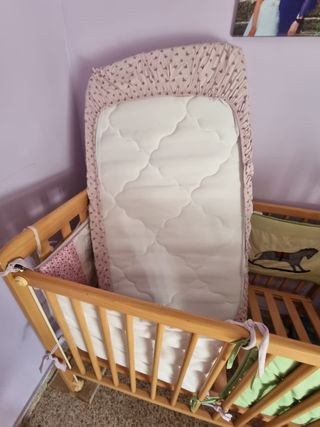 Cuna de madera con colchón y sábanas