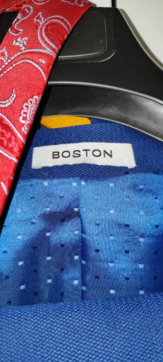 Traje azul con corbata roja y camisa de Lacoste