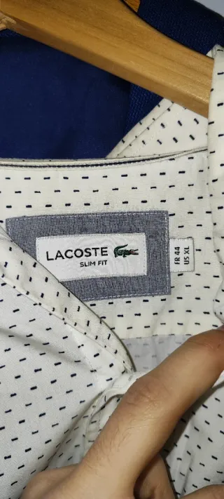 Traje azul con corbata roja y camisa de Lacoste