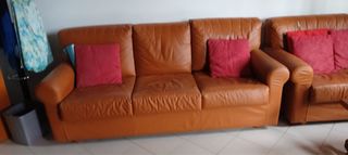 Divano in pelle marrone con cuscini rossi