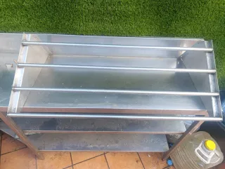 Estantería inoxidable para ollas encima de la pica