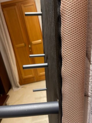 Somier tapizado beige con siete patas metálicas
