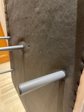Somier tapizado beige con siete patas metálicas