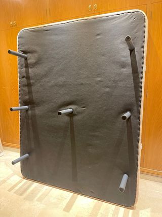 Somier tapizado beige con siete patas metálicas