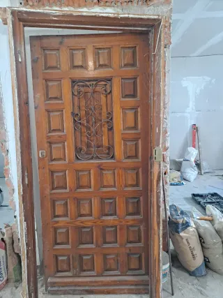 Puerta de madera con reja decorativa