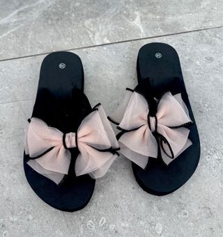 Sandalias negras con lazo rosa