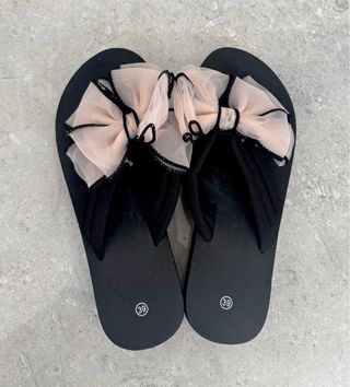 Sandalias negras con lazo rosa