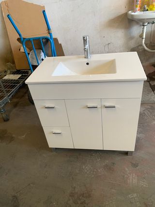Mueble de baño blanco con grifo