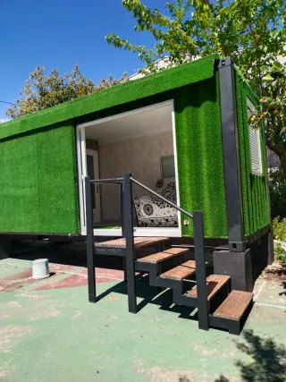 Contenedor mini vivienda con césped artificial