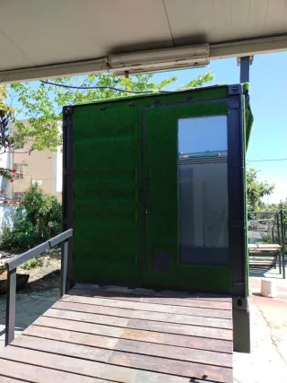 Contenedor mini vivienda con césped artificial