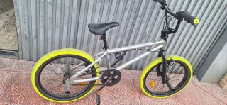 Bicicleta BMX plateada con ruedas amarillas
