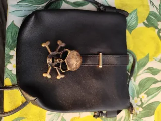 Bolso negro con calavera y detalles dorados