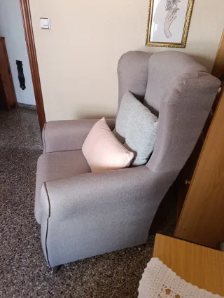Sillón orejero gris con cojín rosa