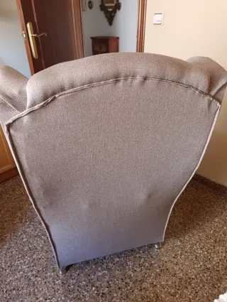 Sillón orejero gris con cojín rosa