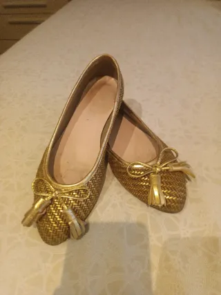 Zapatos planos dorados con lazo