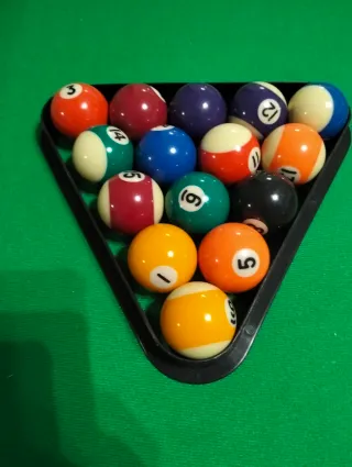Mesa de billar con palos y bolas