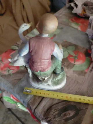 Figura de porcelana hombre con pato y nido