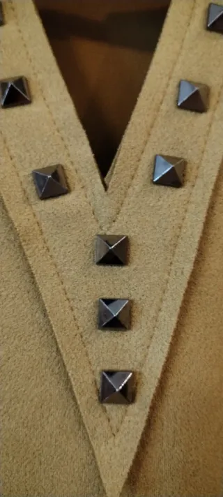 Vestido corto color mostaza con tachuelas.