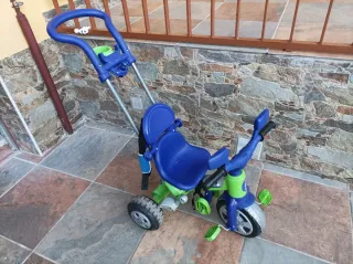 Triciclo para bebé con manillar.