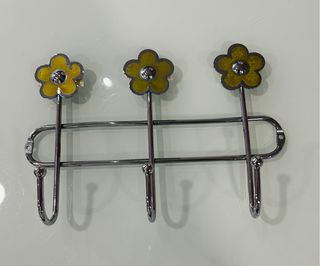 Perchero de acero con flores amarillas