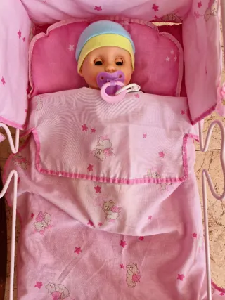 Muñeco bebé con cuna rosa