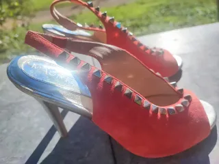 Zapatos de tacón rojos con tachuelas doradas