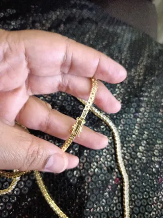 Collar y pulsera dorados con piedras blancas