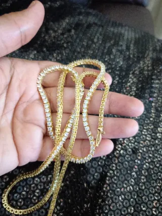 Collar y pulsera dorados con piedras blancas