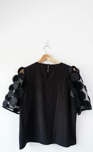 Camisa negra con mangas de tul y apliques 3D