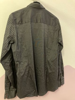 Traje de hombre negro a rallas finas con camisa.