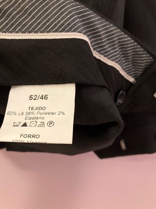 Traje de hombre negro a rallas finas con camisa.