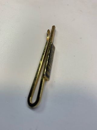 Aguja de corbata dorada con detalle negro