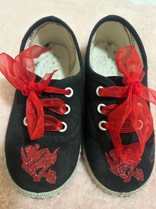 Zapatillas negras con lazo rojo y adorno