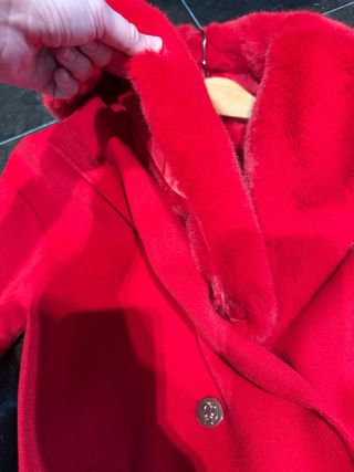 Abrigo rojo con cuello de pelo desmontable.