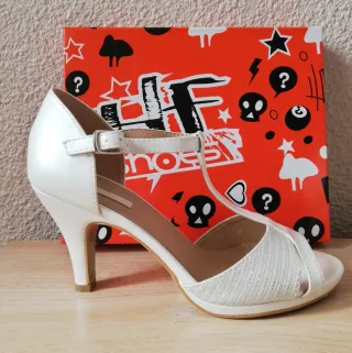 Sandalias de tacón blancas.