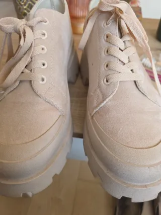 Zapatos beige con cordones. No son de marca.