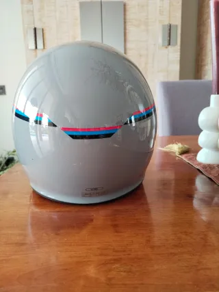 Casco de moto gris con diseño deportivo retro