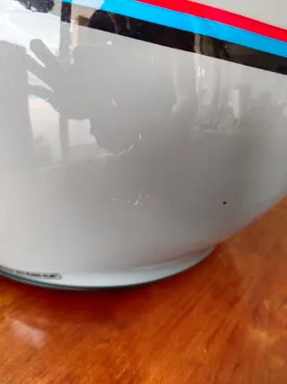 Casco de moto gris con diseño deportivo retro