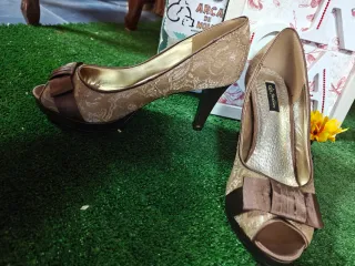 Zapatos de tacón dorados con lazo