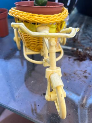 Bicicleta decorativa amarilla con maceta