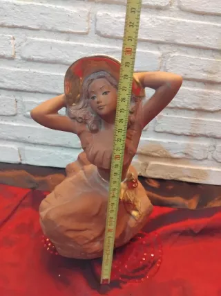 Figura de mujer con sombrero dorado