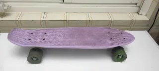 Monopatín morado con ruedas verdes
