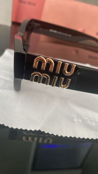 Gafas de sol Miu Miu negras y doradas