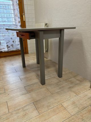 Mesa naranja y gris con dos banquetas negras