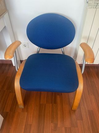 Sillón azul cómodo con brazos de madera.