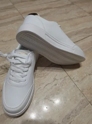 Zapatillas Fashion blancas con detalle dorado.